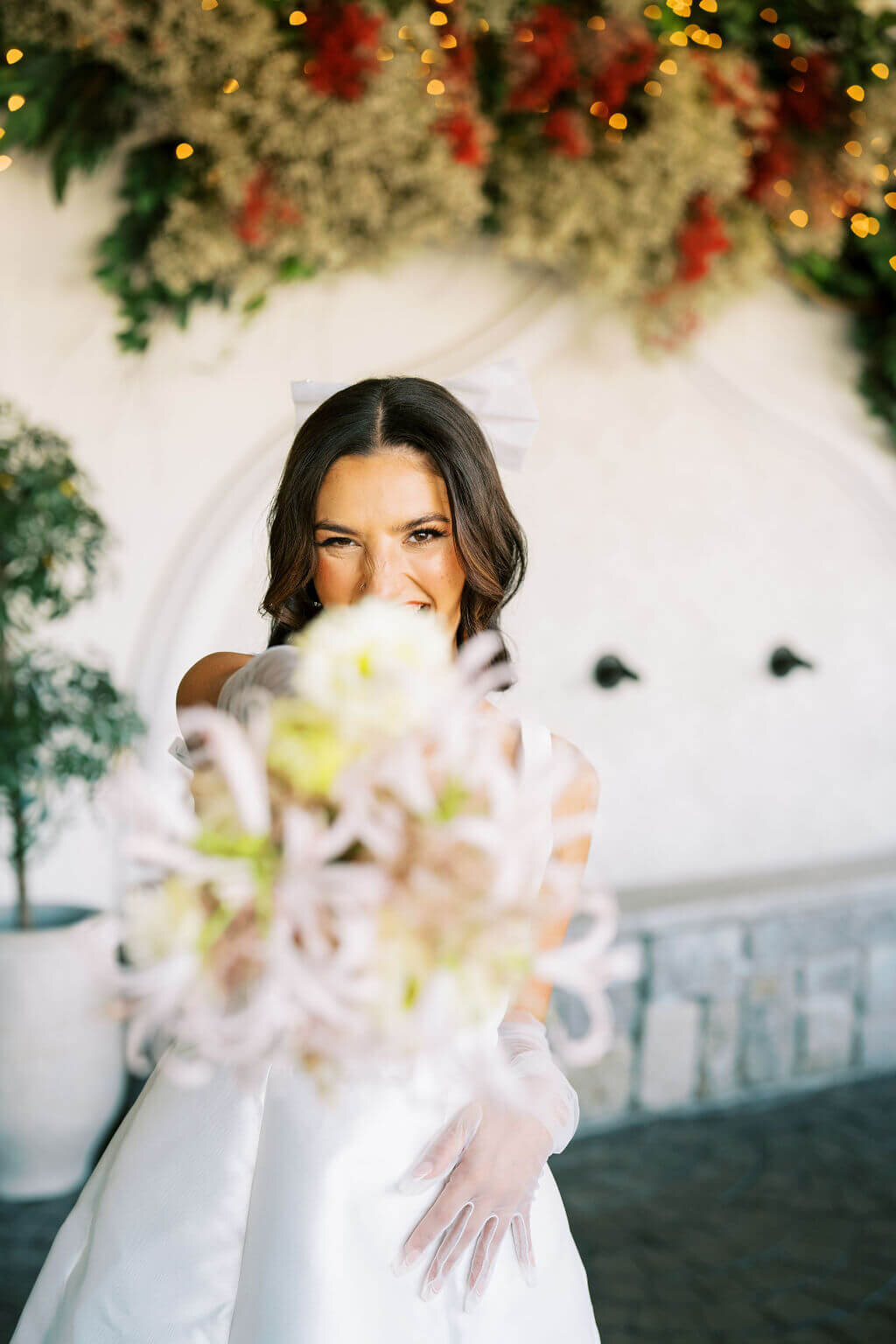 Bride wearing a white dress and gloves holding her bridal bouquet