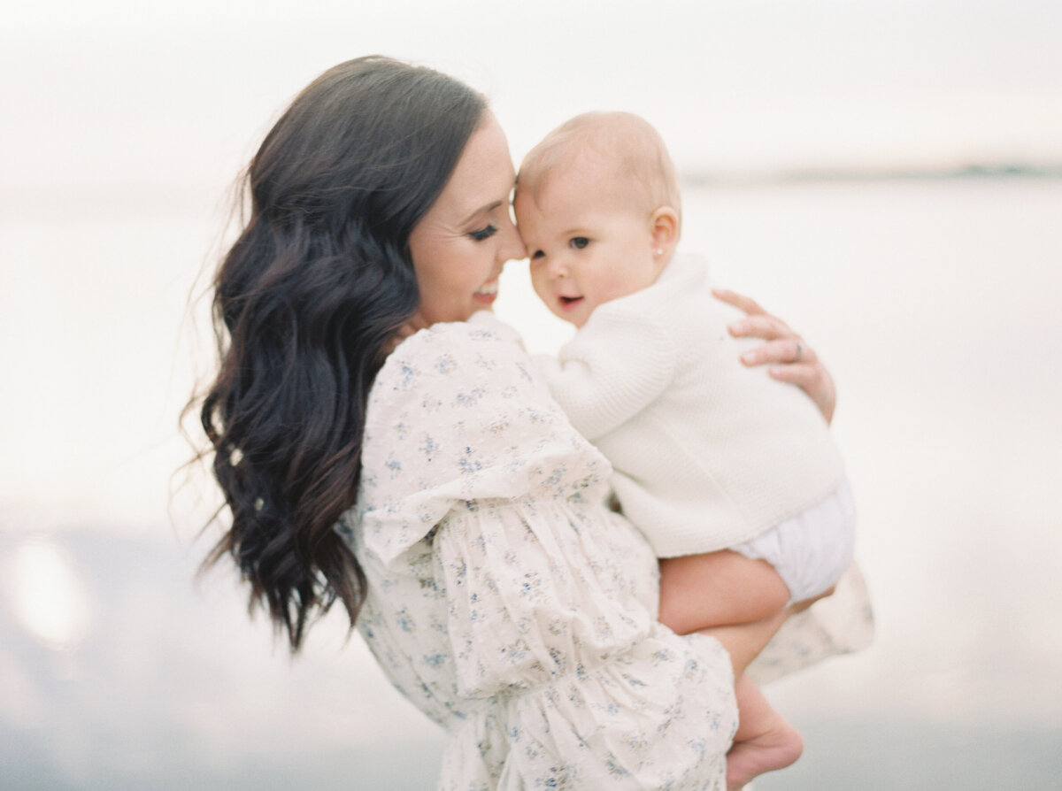 Mother holding baby by the ocean