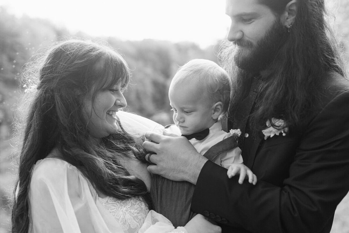 bride and groom holding baby in the middle