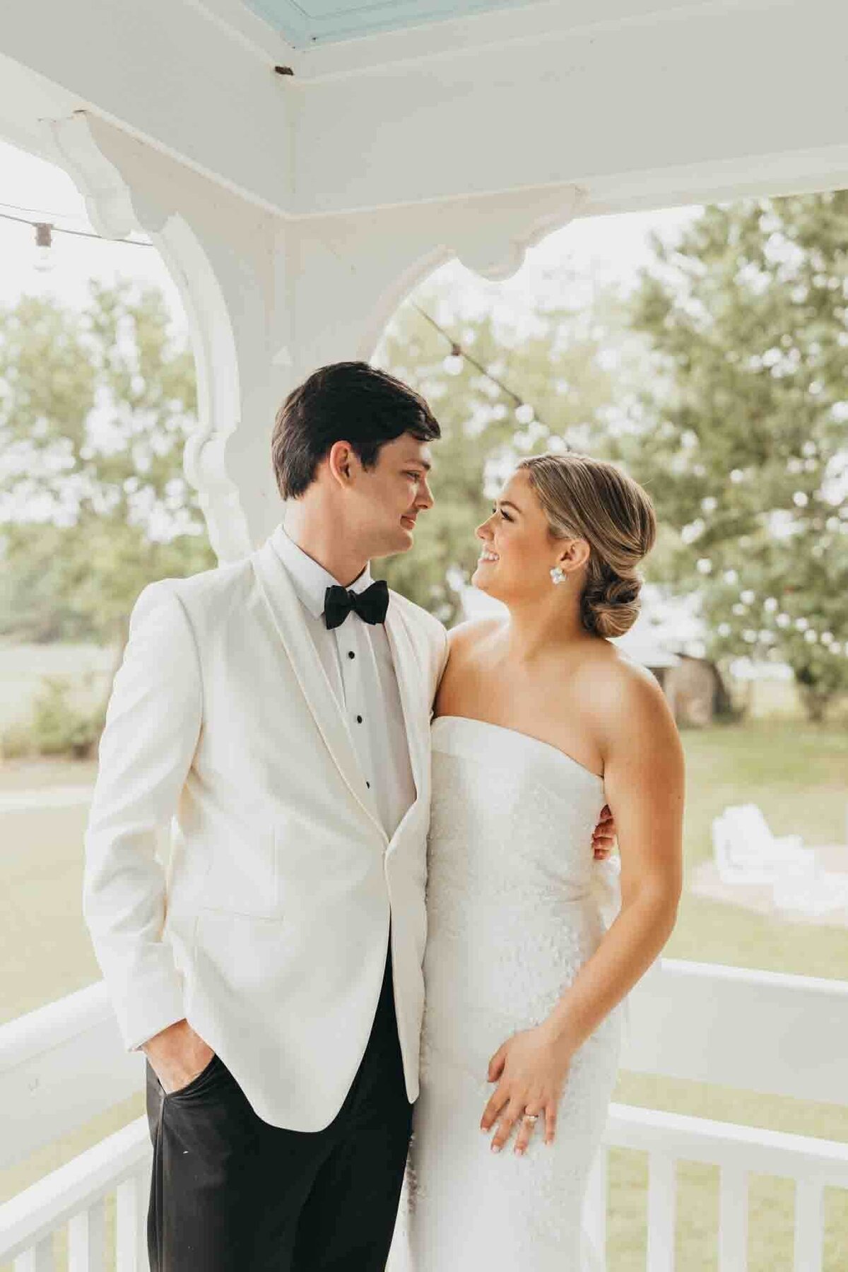 bride and groom stare lovingly at each other during their first look while standing on porch