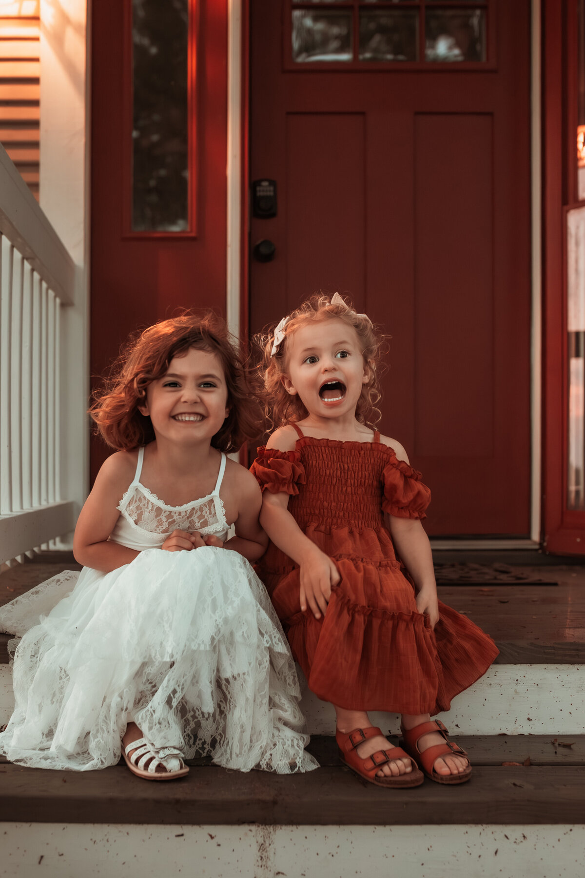 siblings-in-dresses-laughing-on-steps