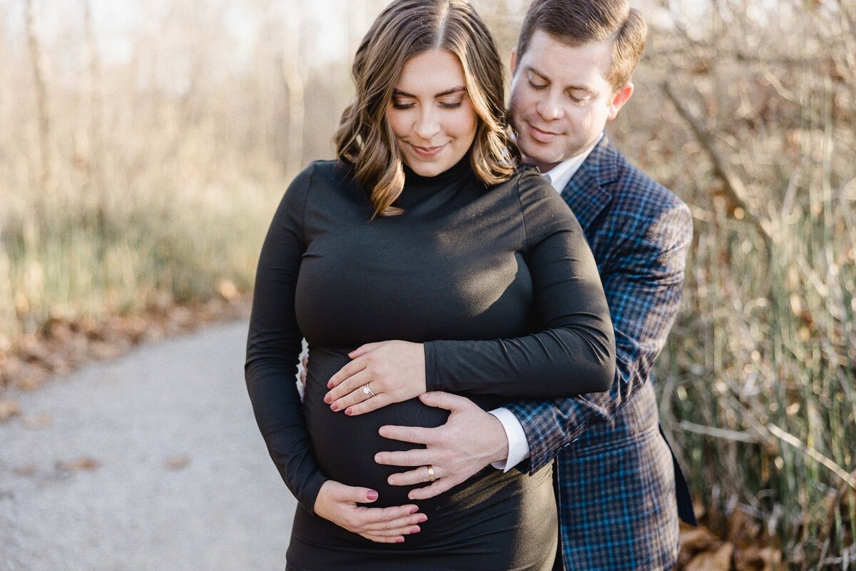 husband hugging pregnant wife from behind