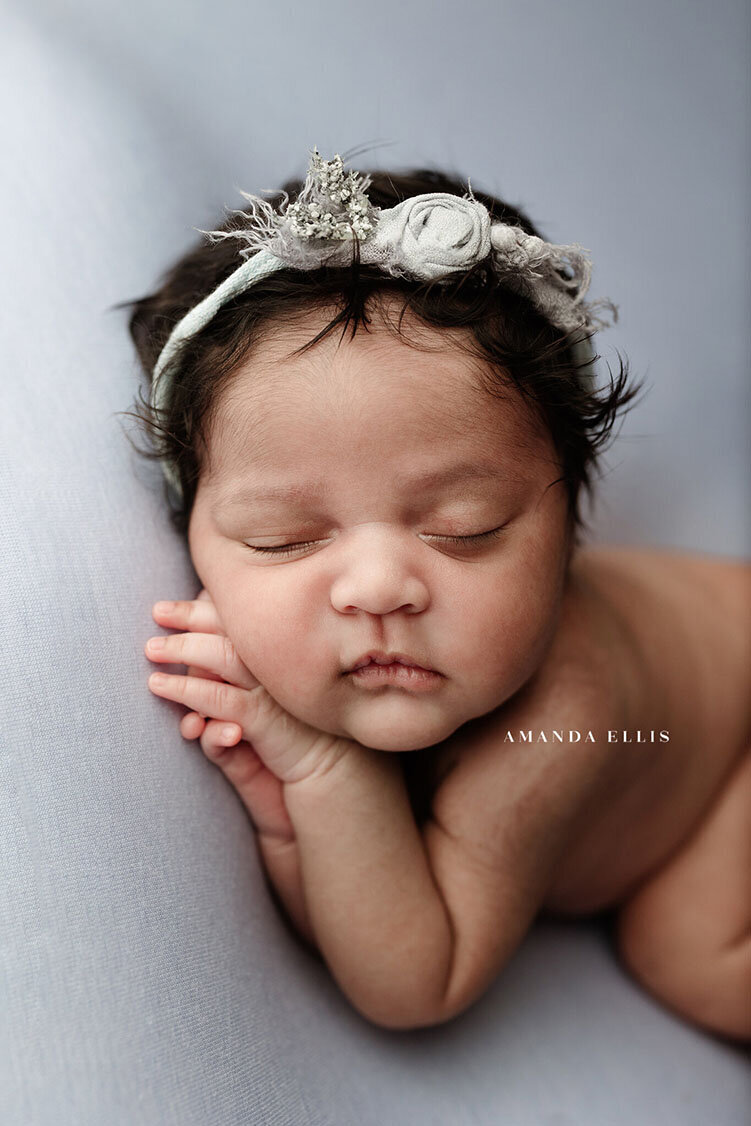 Angelic newborn portrait of baby on white sheet