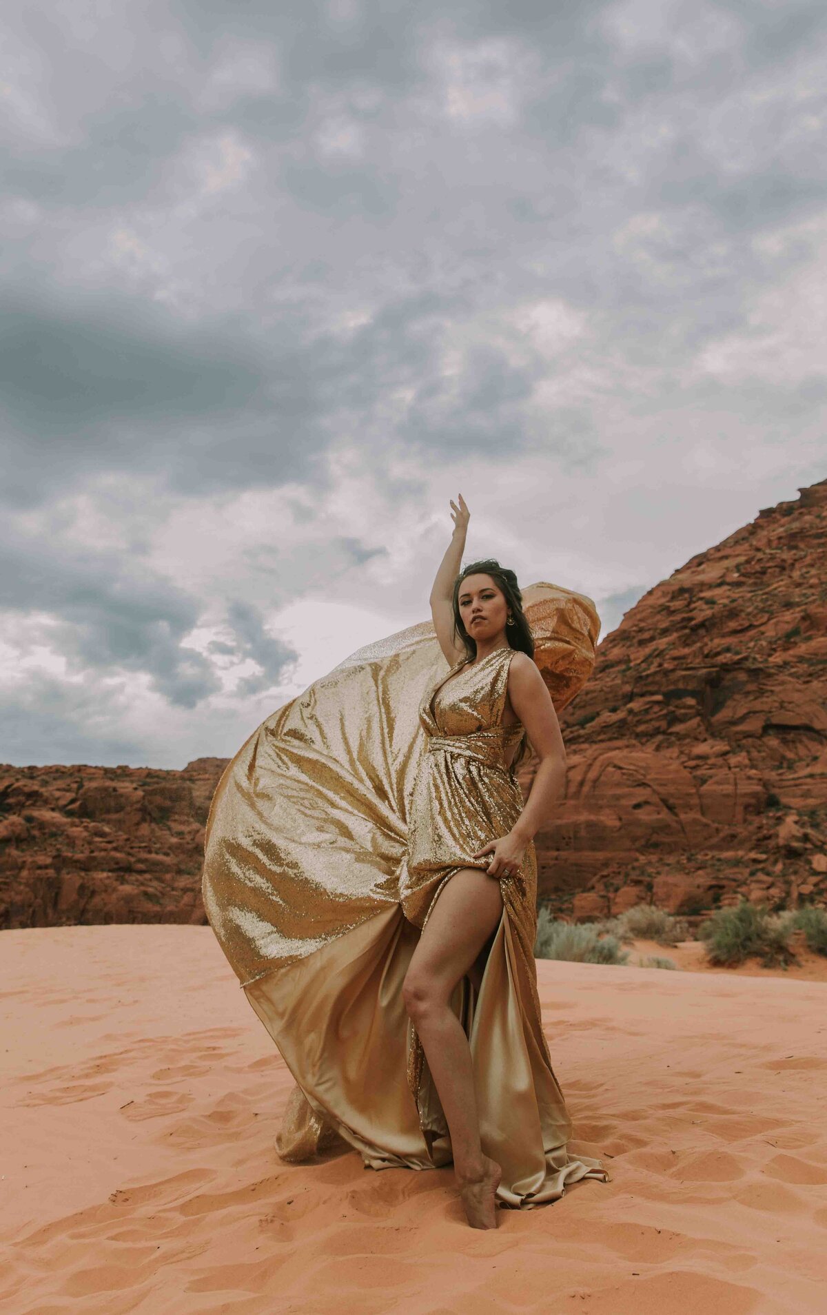 Woman in a gold dress at the sand dunes