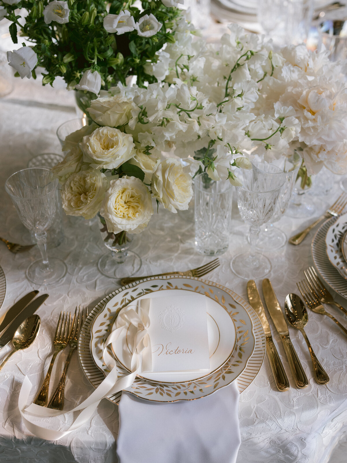 Gold and white chargers, china, flatware with ribbon menu card