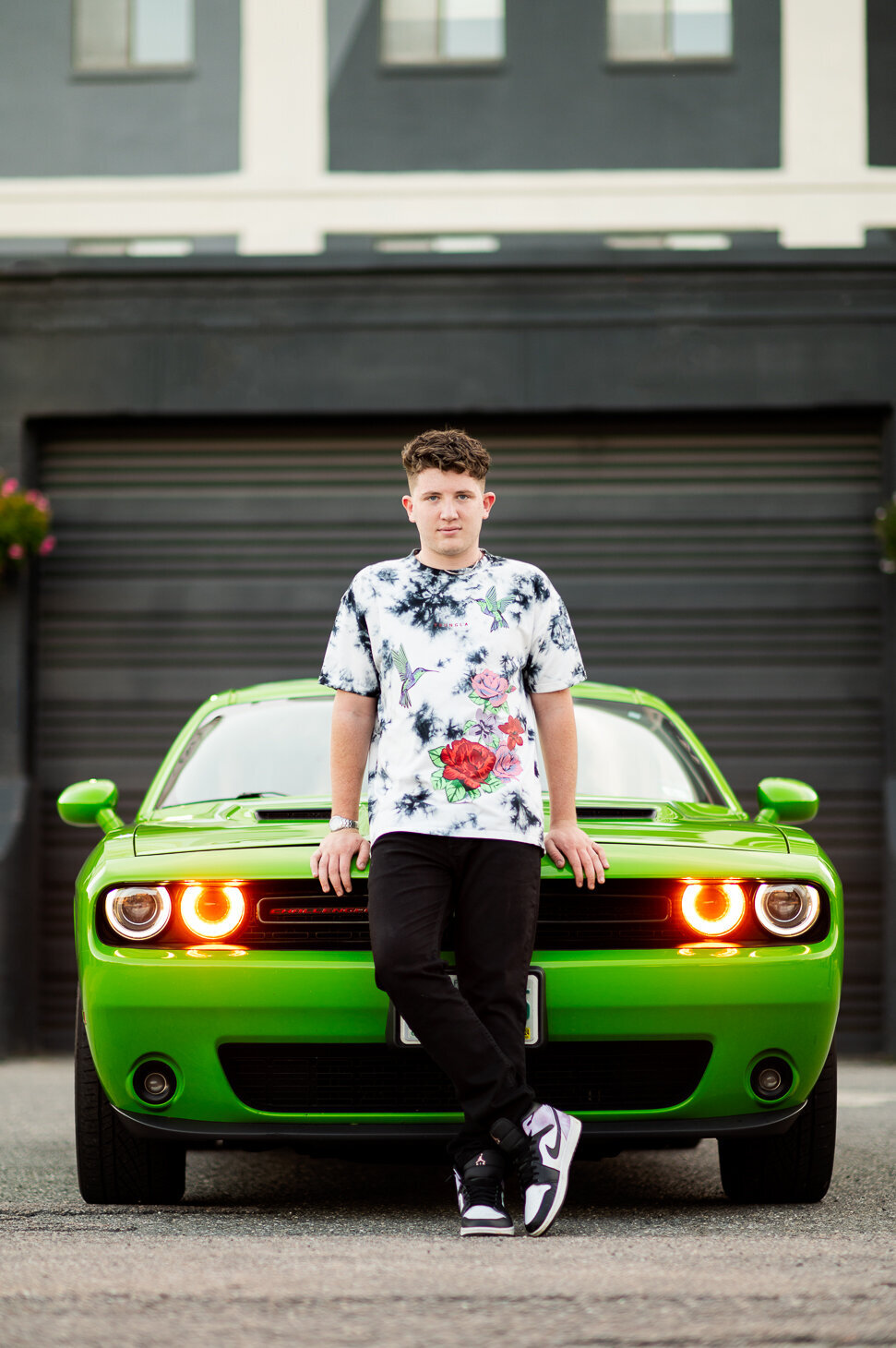 A Nashua South high school senior posing in front of a green sports car.