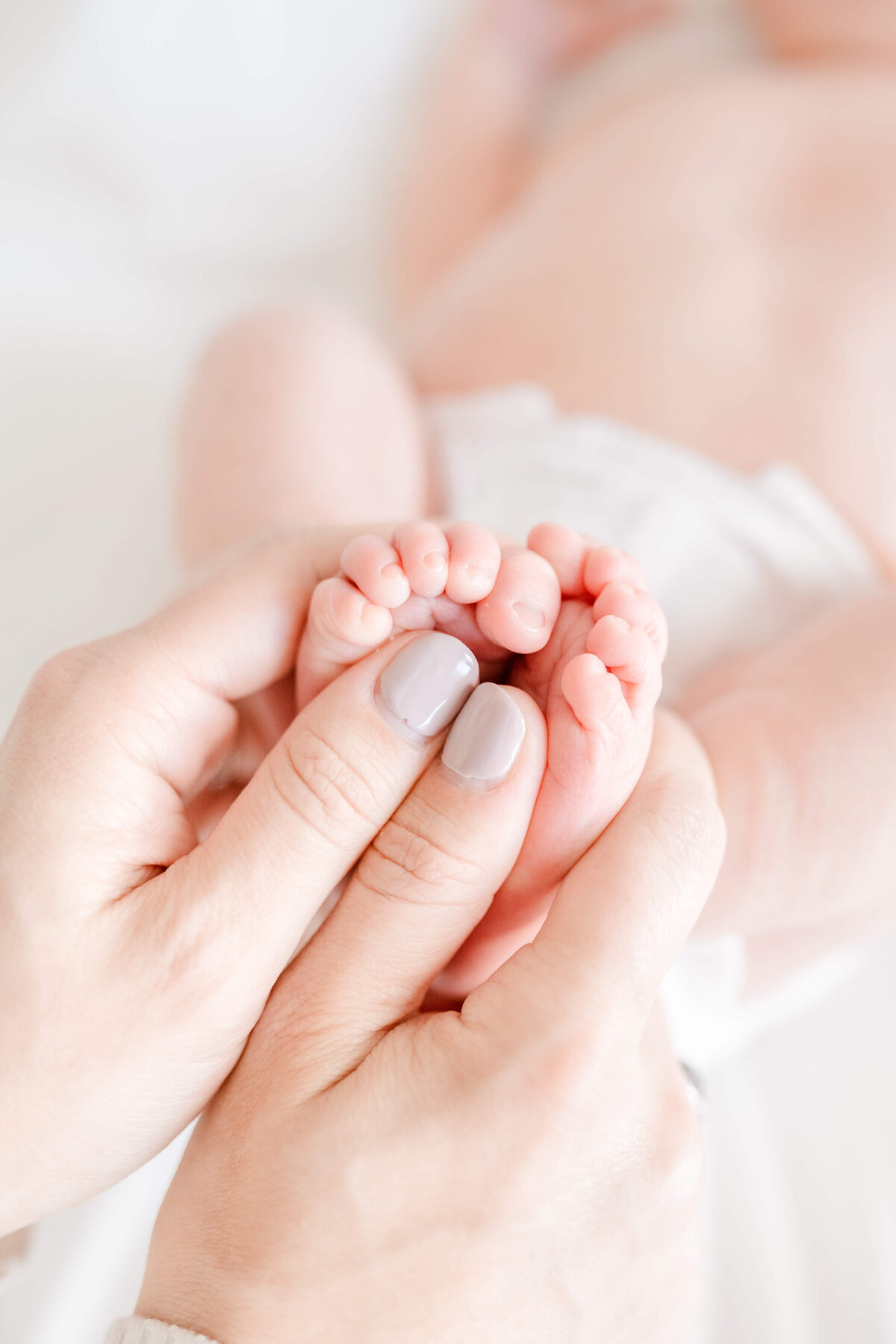 Bay Area newborn photographer capturing baby girl swaddled in soft neutral blanket during in-home session.