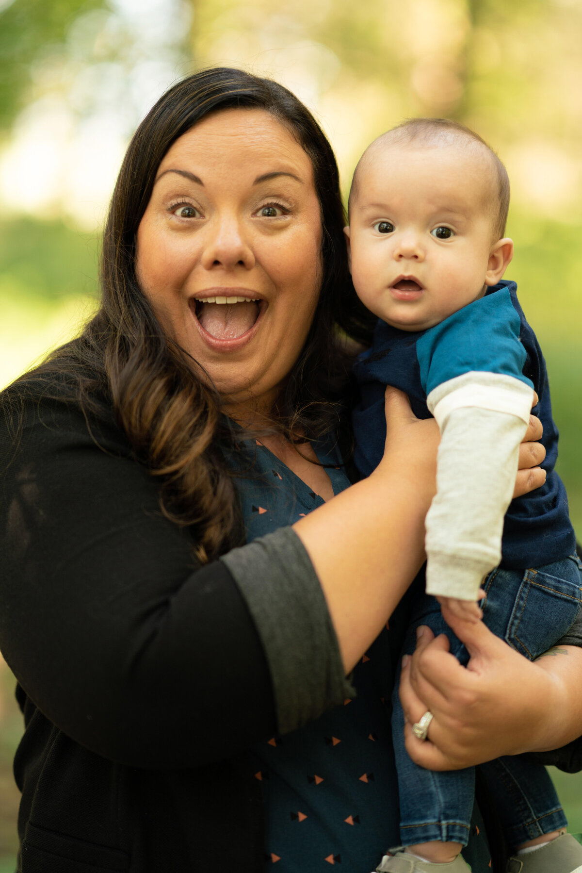 Mom laughs with baby looking at the camera.