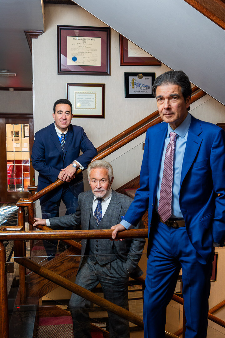 Professional corporate headshot of group of executives in suits seated in decorated office space new jersey