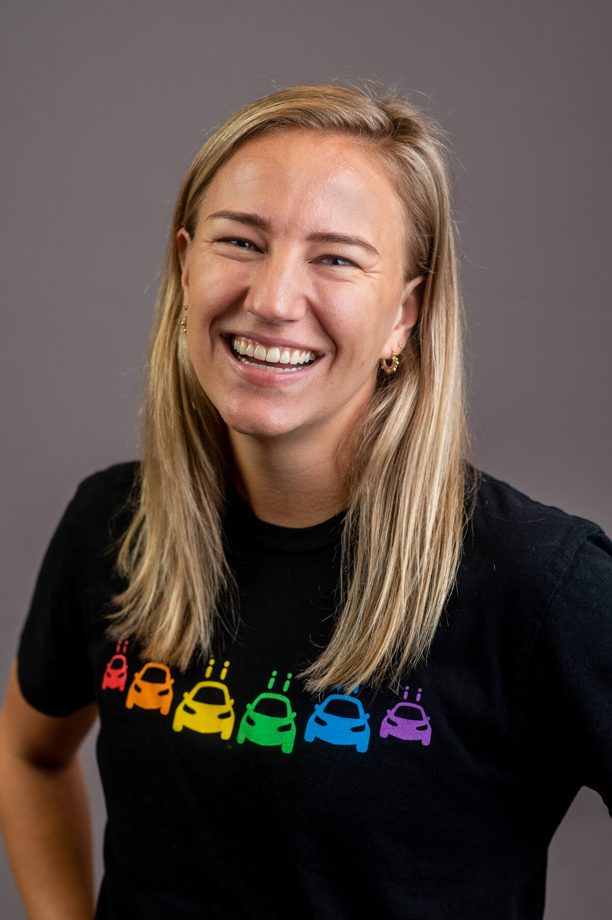 a blonde woman wearing a black t-shirt with rainbow logo on the front