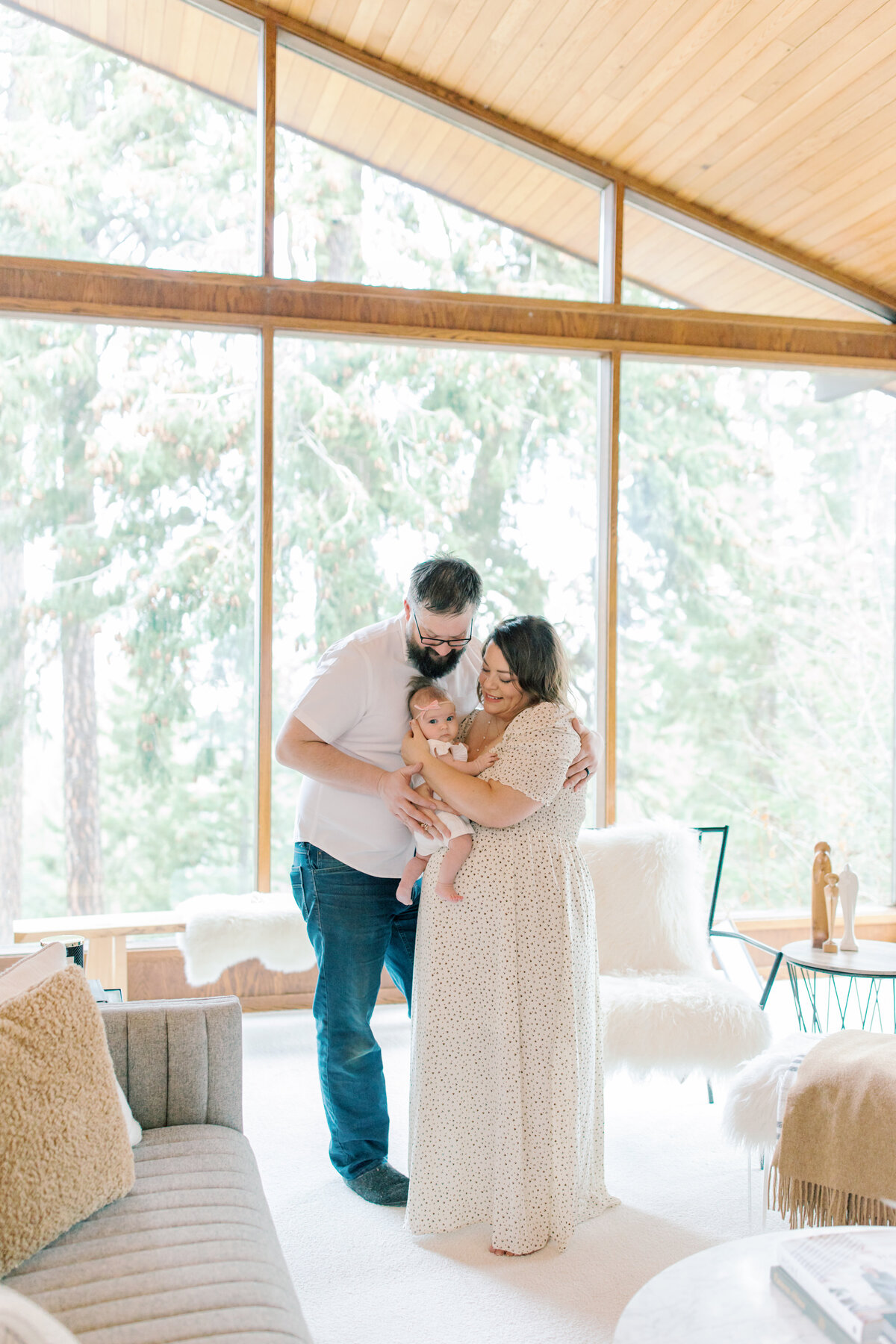 spokane newborn photography image with mom and dad holding newborn baby in their living room