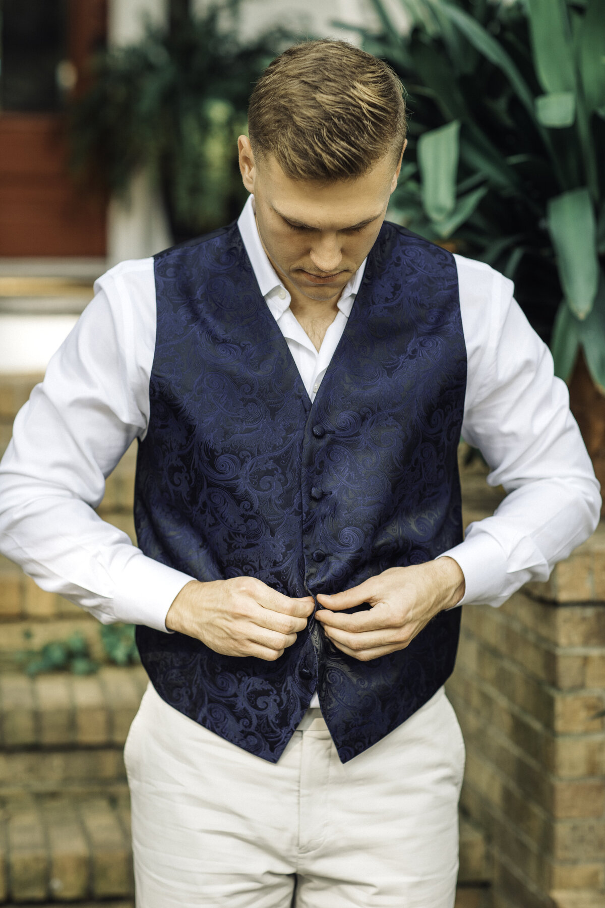 Wedding Photograph Of Groom Buttoning His Blue Vest Los Angeles