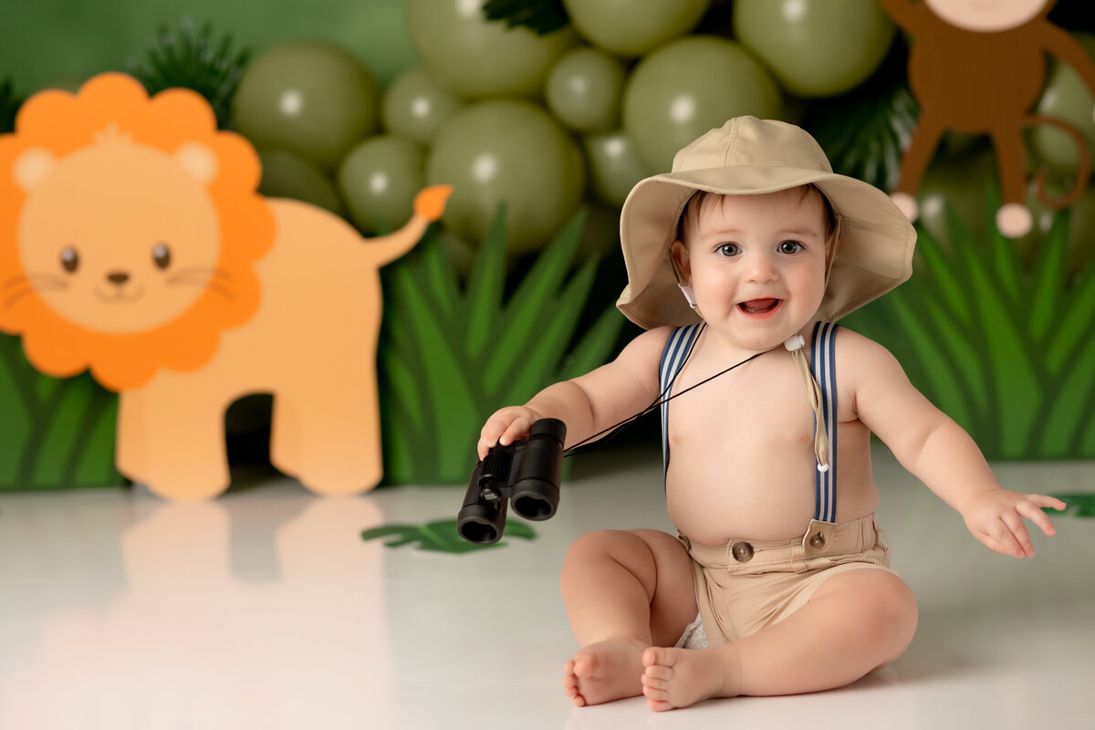 One year old Tampa baby enjoying a personalized luxury cake smash session with safari decorations