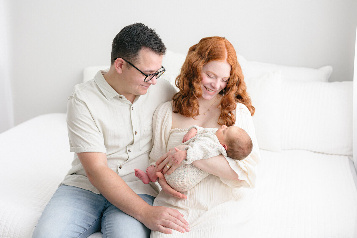 New mom and dad holding their newborn baby during their northern kentucky newborn photography session with missy marshall
