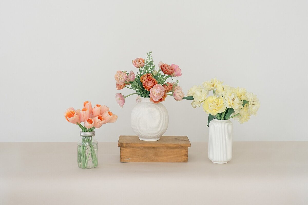 florist brand photos with three vases arranged with pink and yellow florals photographed by brand photographer