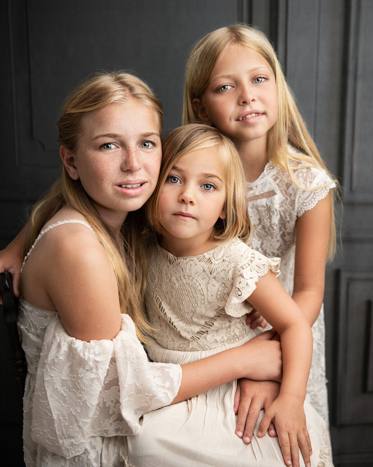 three sisters portrait against grey backdrop website