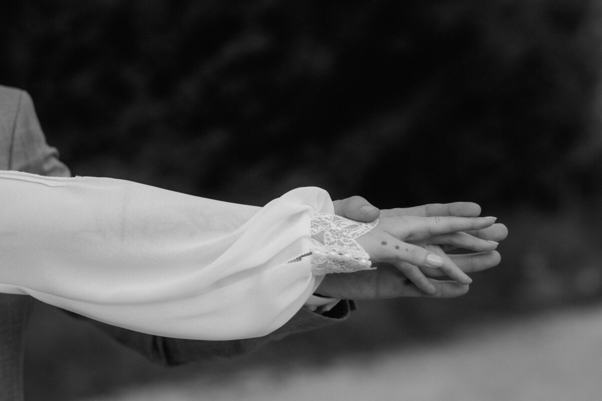 Deatilshot of the wedding couple holding their hands stretched out.