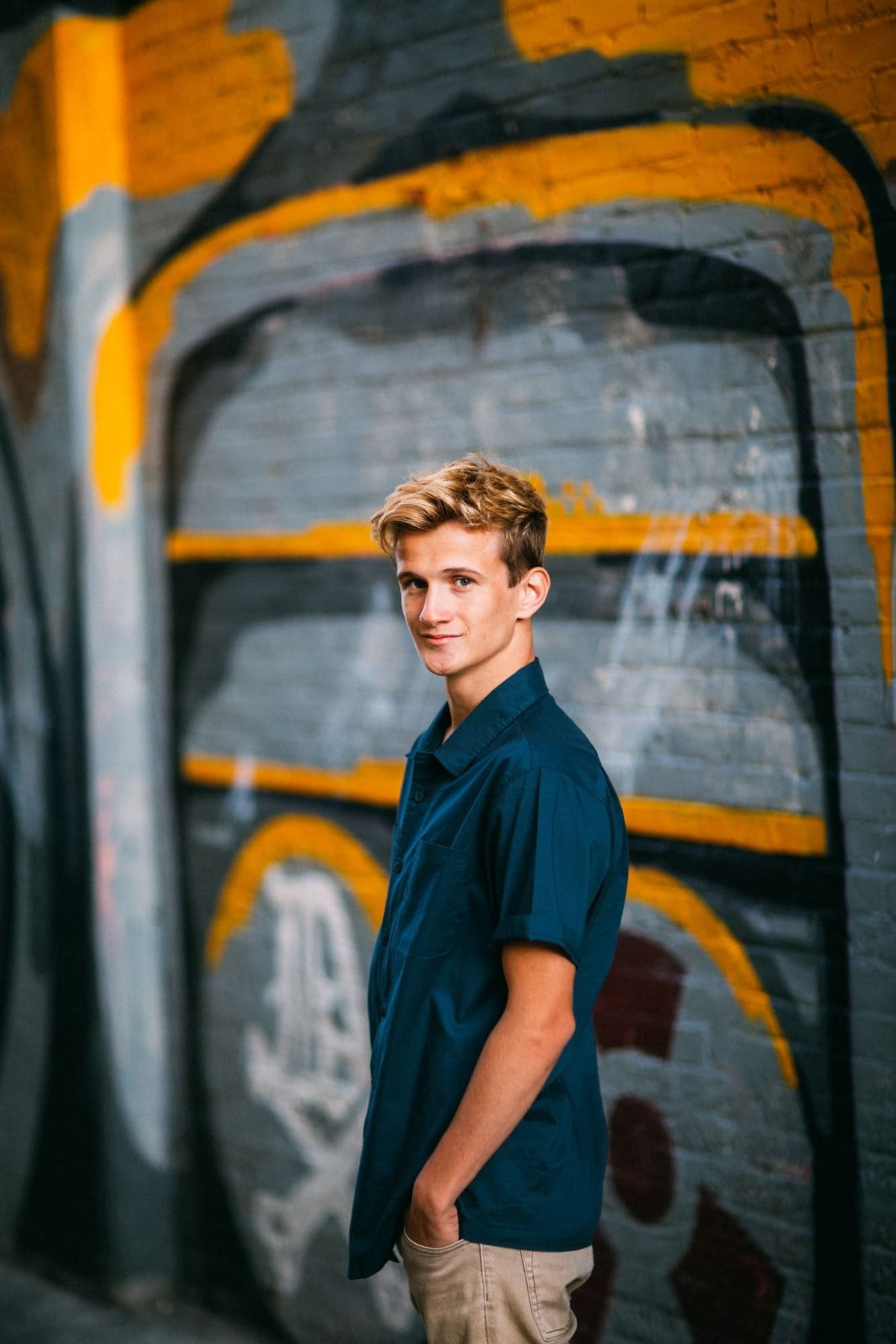 High School senior poses for senior portraits in front of a mural in Santa Ana