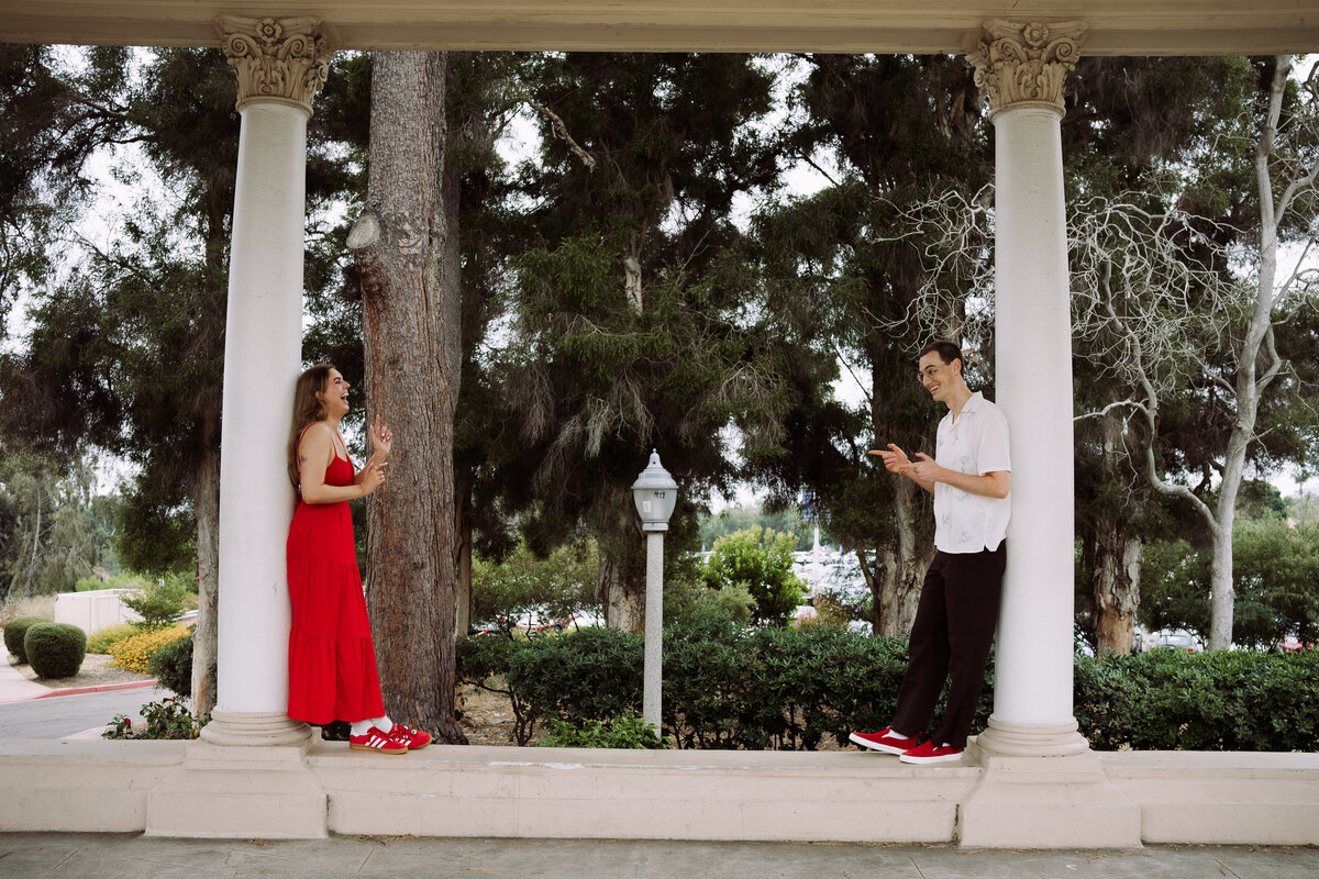 man and woman leaning against outdoor pillars