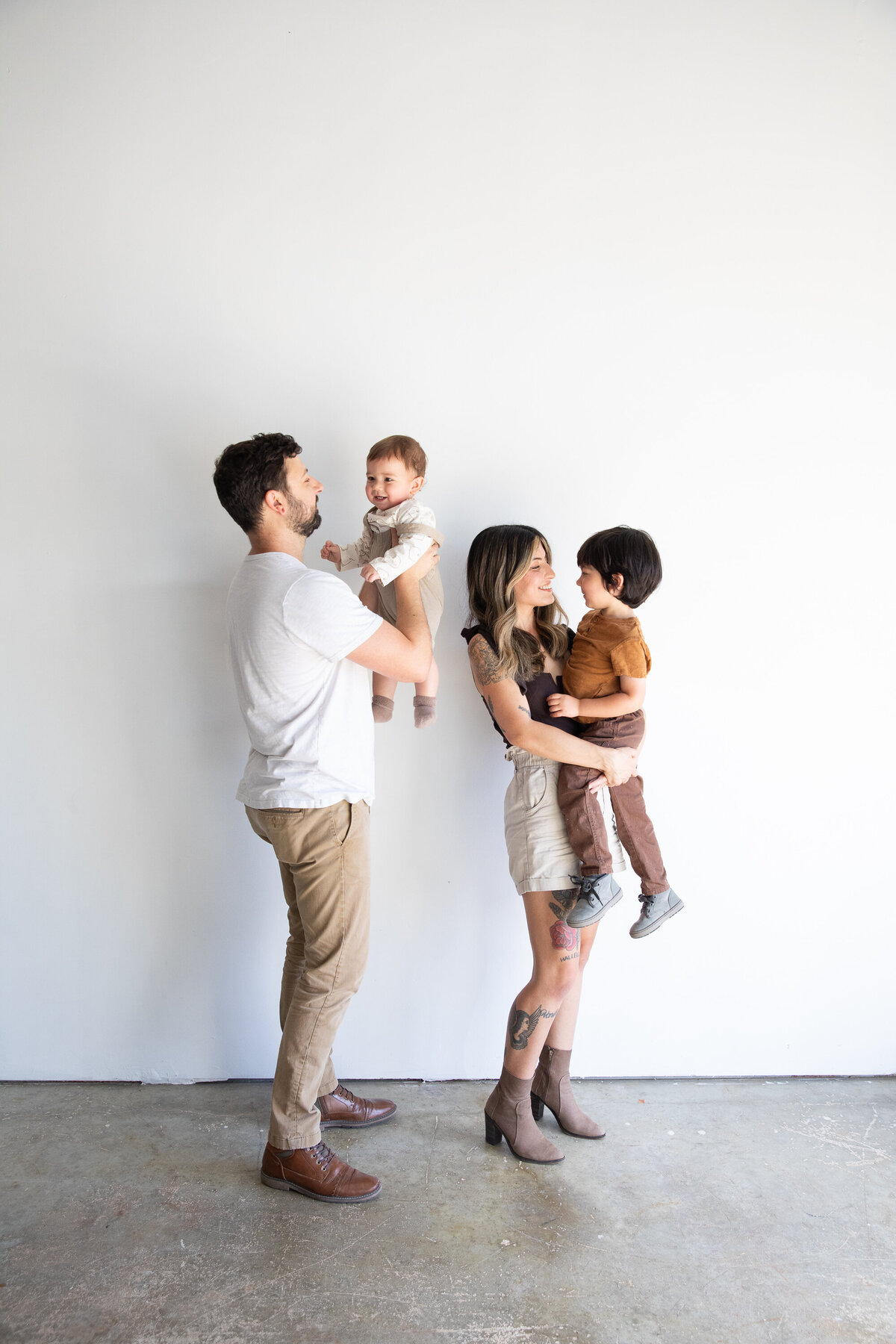 An Austin wedding photographer captures a family standing in front of a white wall.