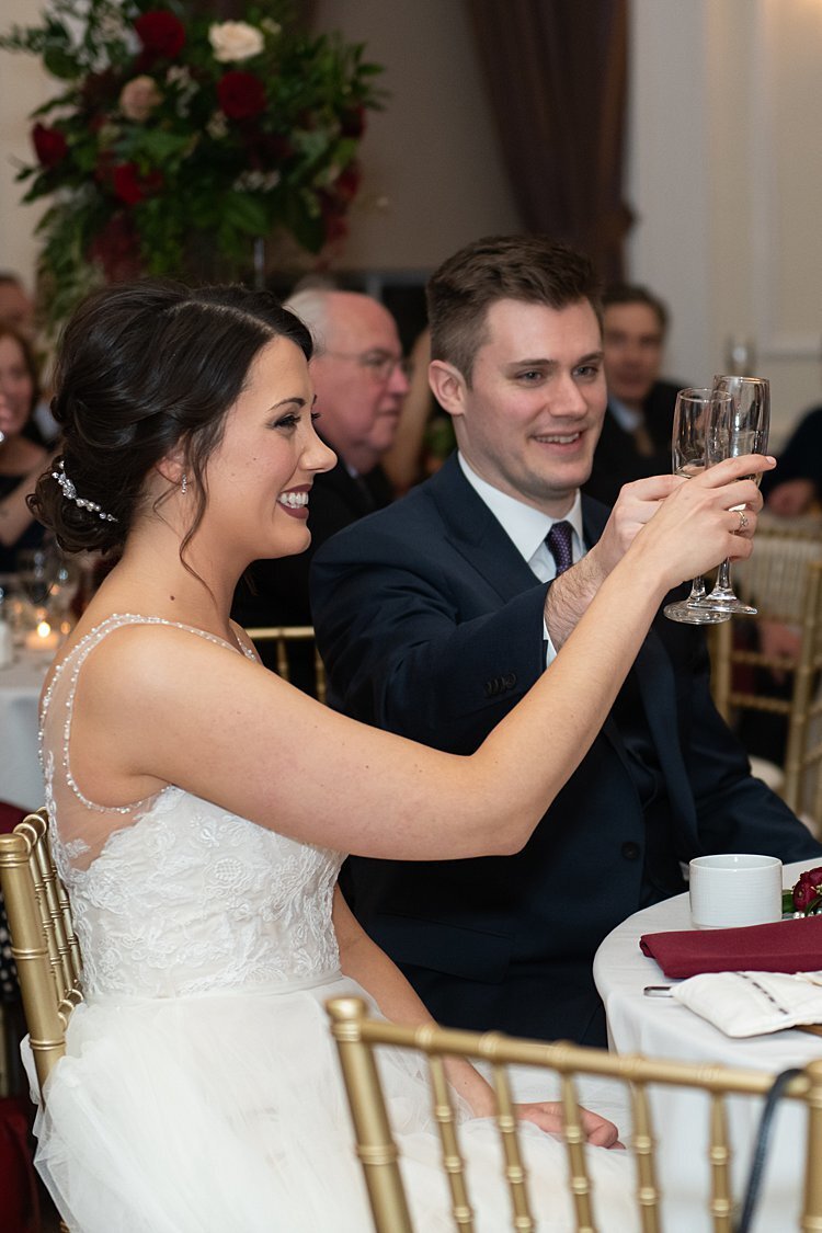 Happy Bride raising her glass with Groom during toast at University Club in Pittsburgh, PA