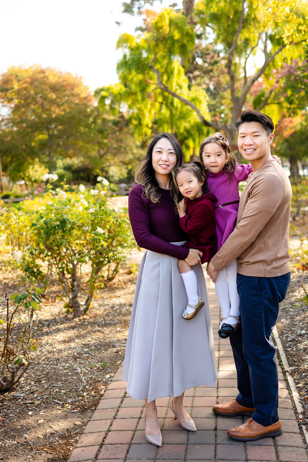 Family posing together on a garden path in San Mateo during their Bay Area family session – Ellobelle Photography