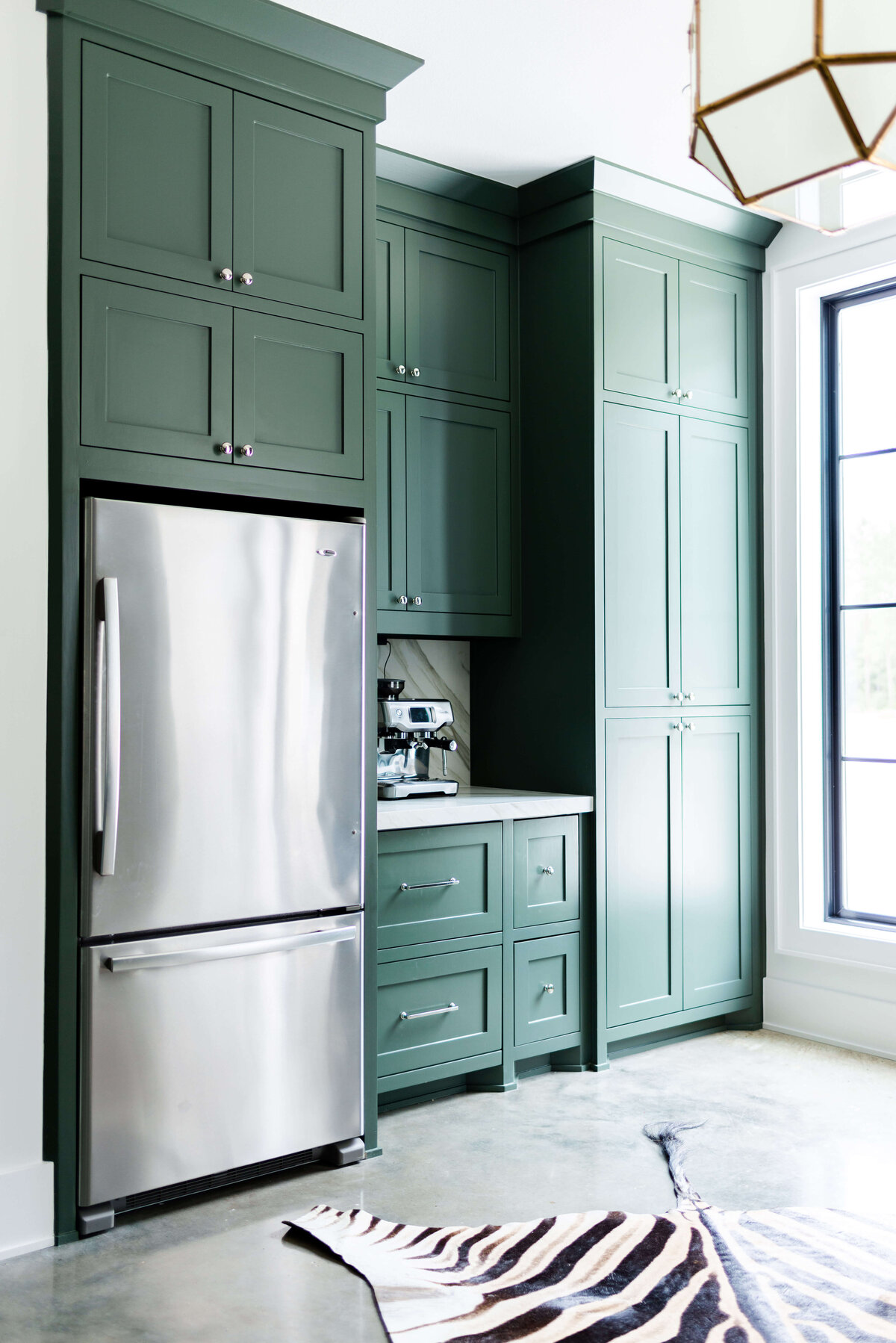 oyster creek studios building belt new build  large hunter green cabinet with zebra rug and stainless stell refridgerator
