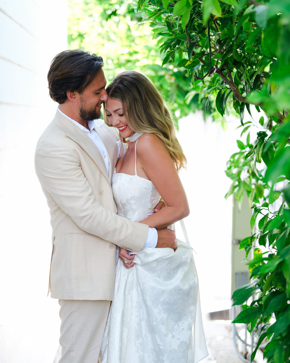 Bride and groom embracing at backyard wedding in San Diego