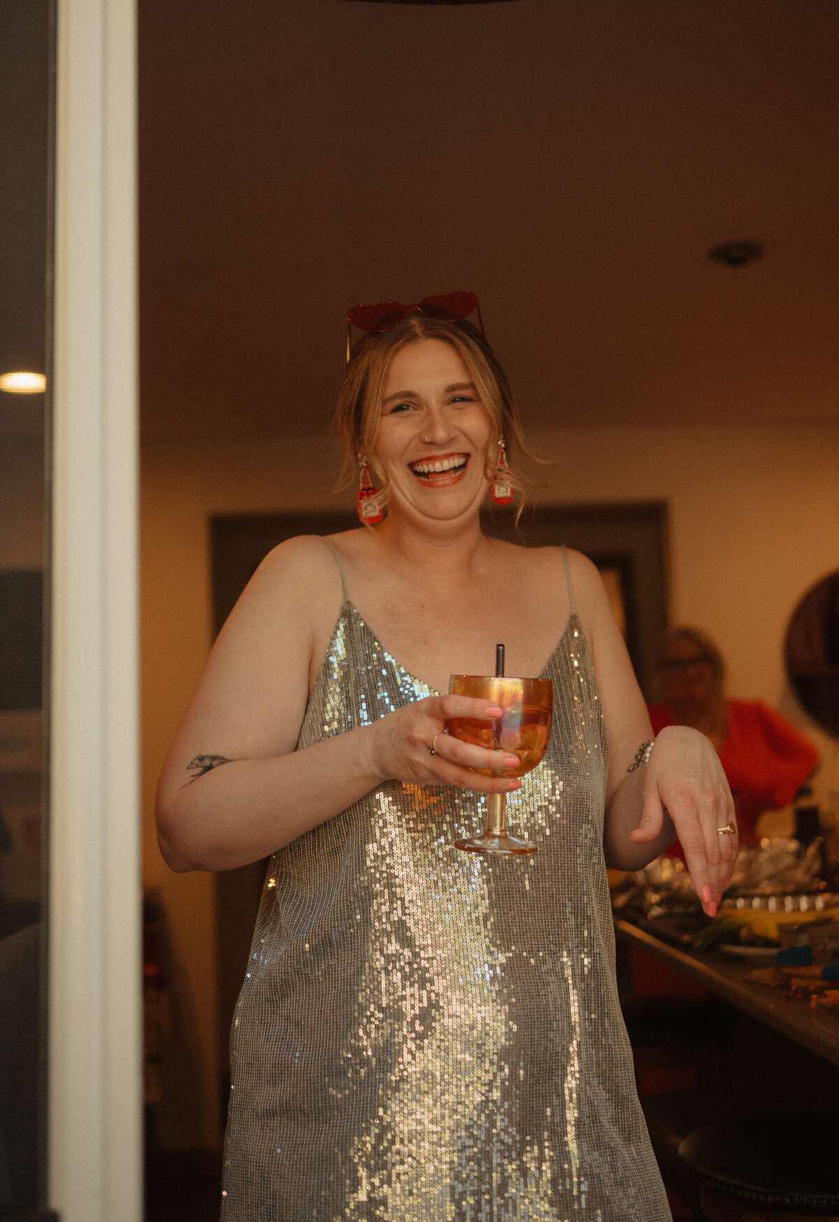 bride wears a glittery dress, holds a drink, and smiles big on her elopement day in Bend, OR