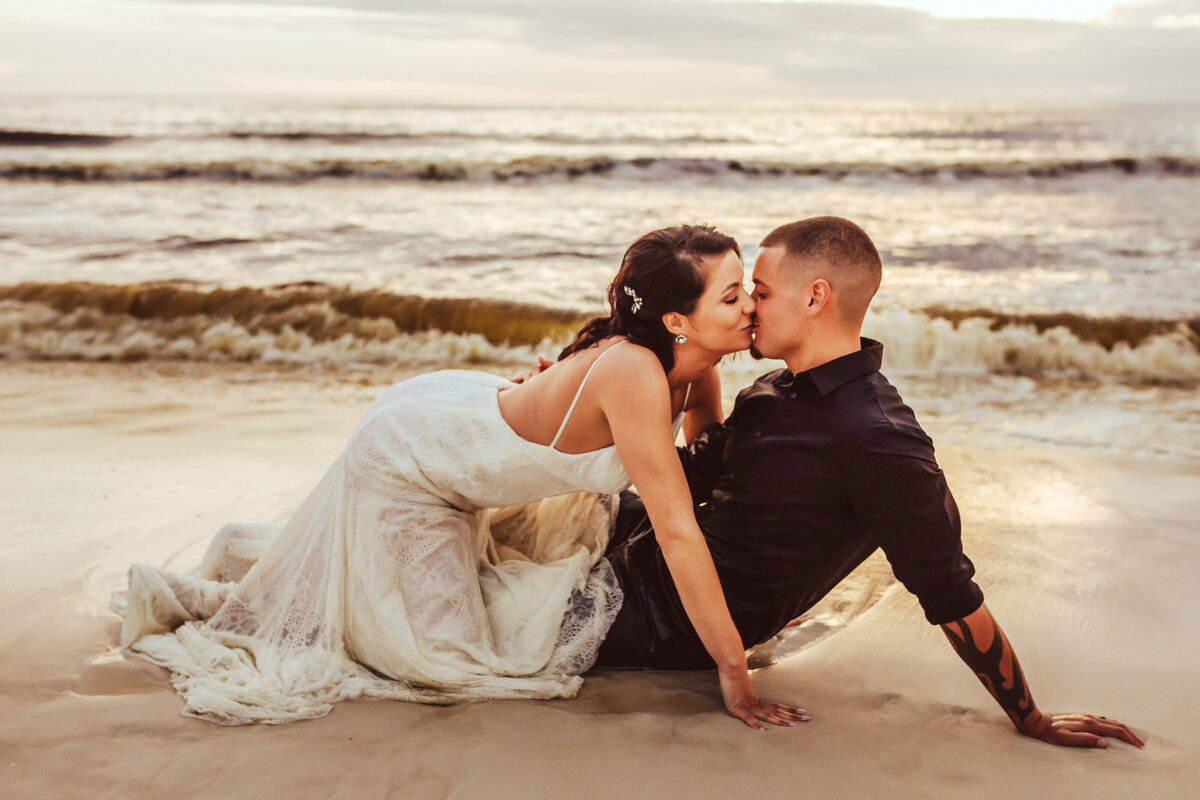 newlyweds kiss intimately on beach in pcb fl following intimate wedding ceremony