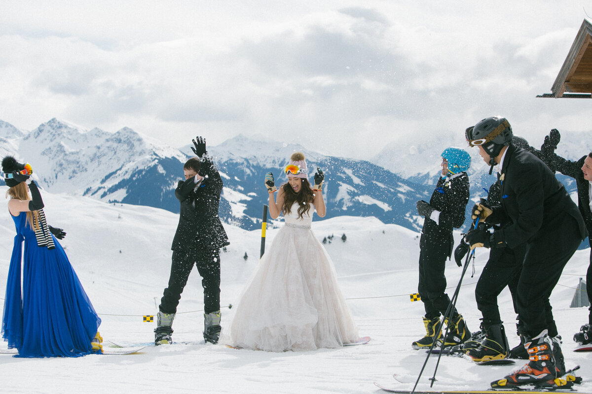 Bride throwing snowball during playful snowy wedding session in Kitzbühel – candid alpine moment by Studio Rose