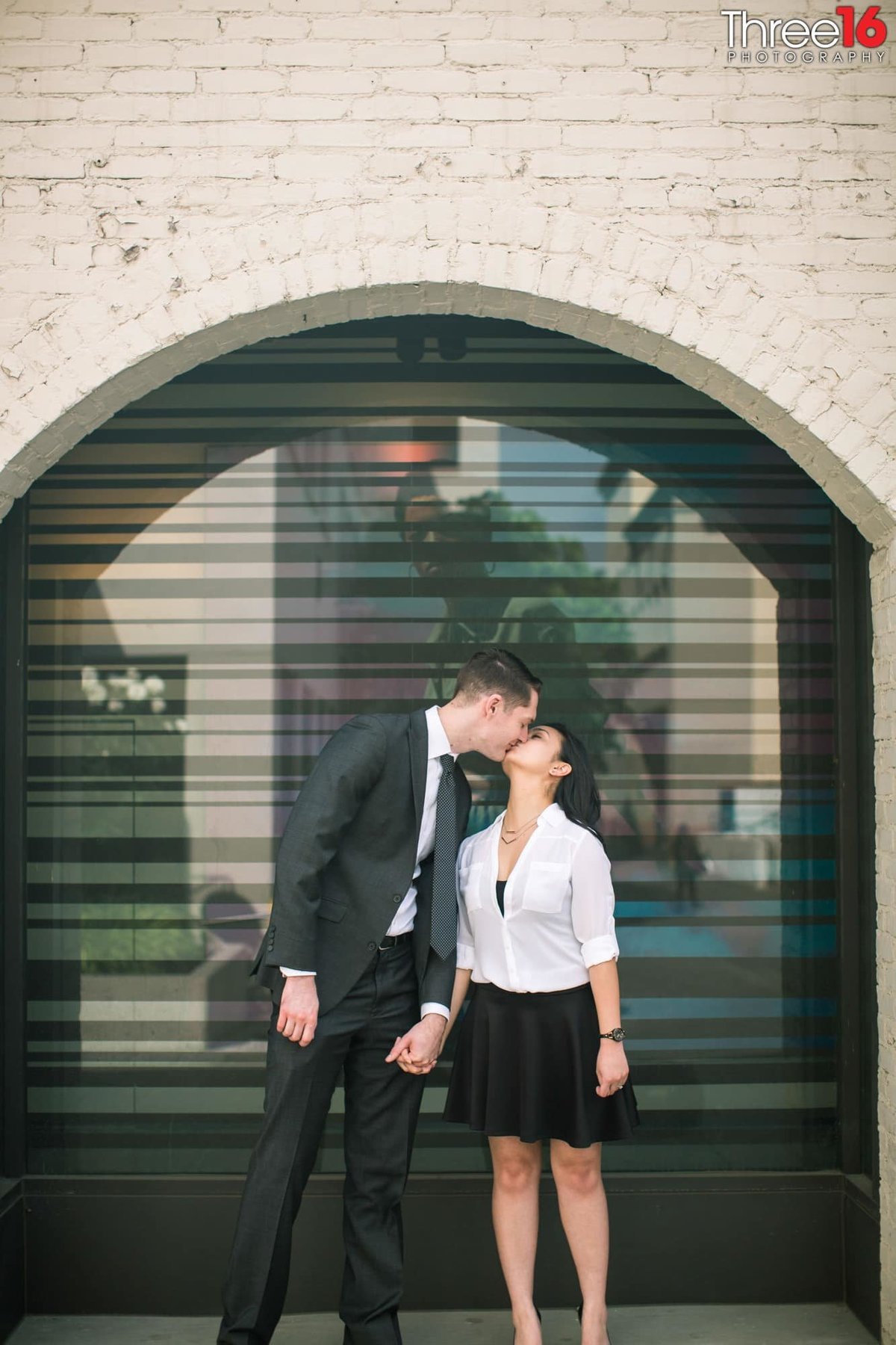 Engaged couple share a romantic kiss during photo session
