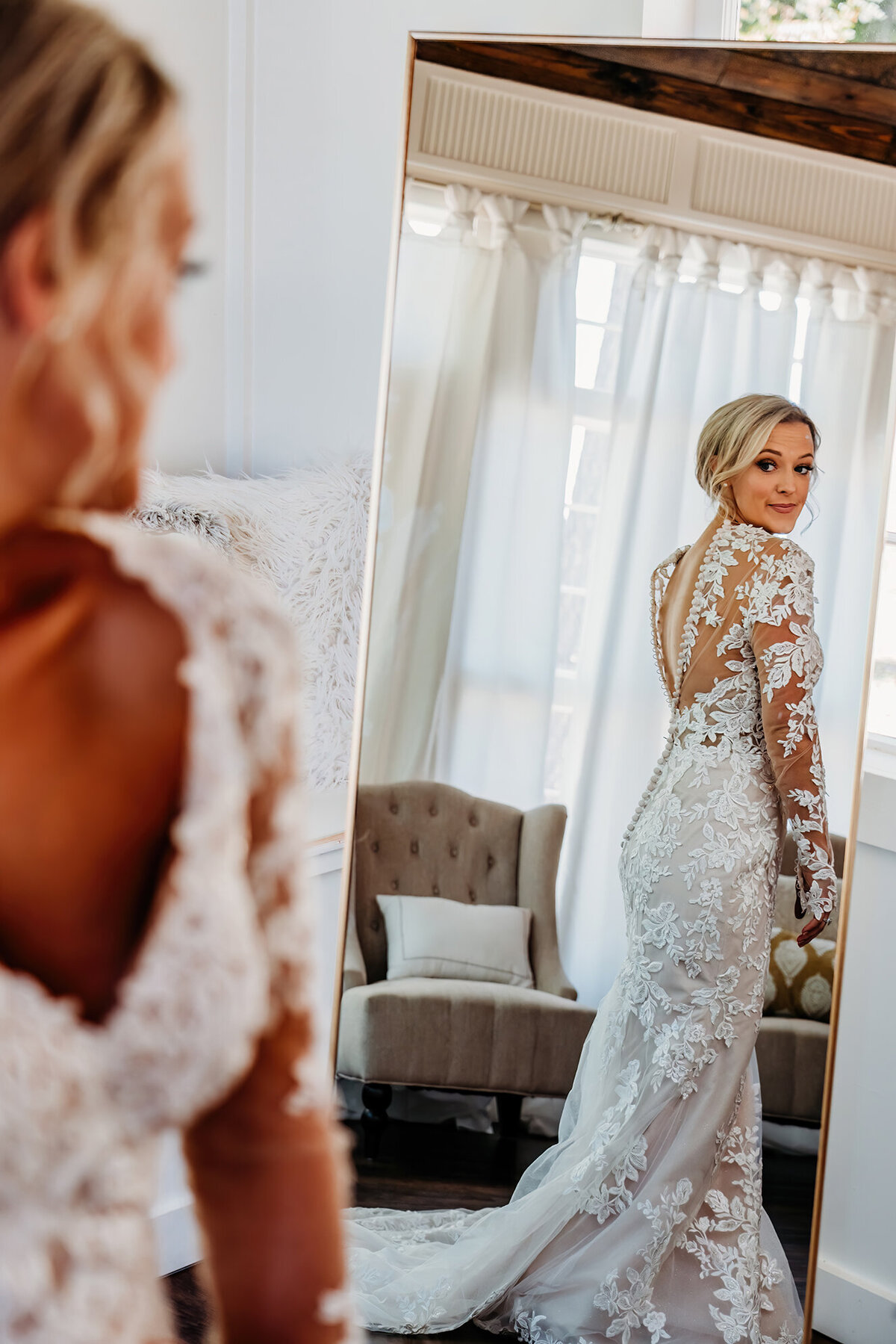 a photo of a bride looking at her dress through a mirror