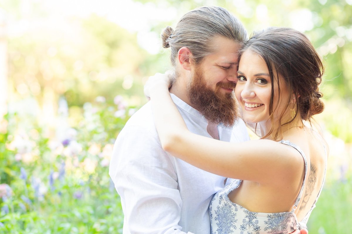 Engaged couple embracing in a filed of flowers