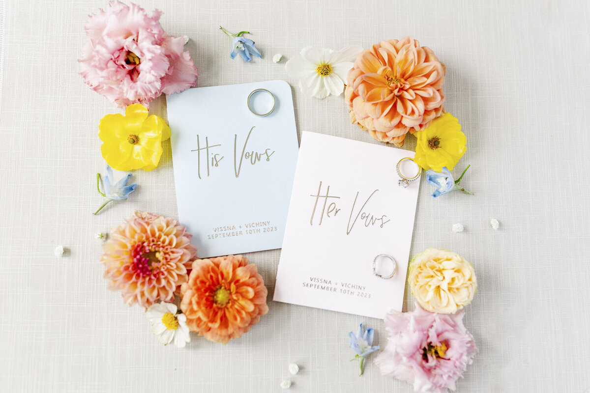 flat lay of colorful stationery surrounded by vibrant orange, pink, and yellow flowers