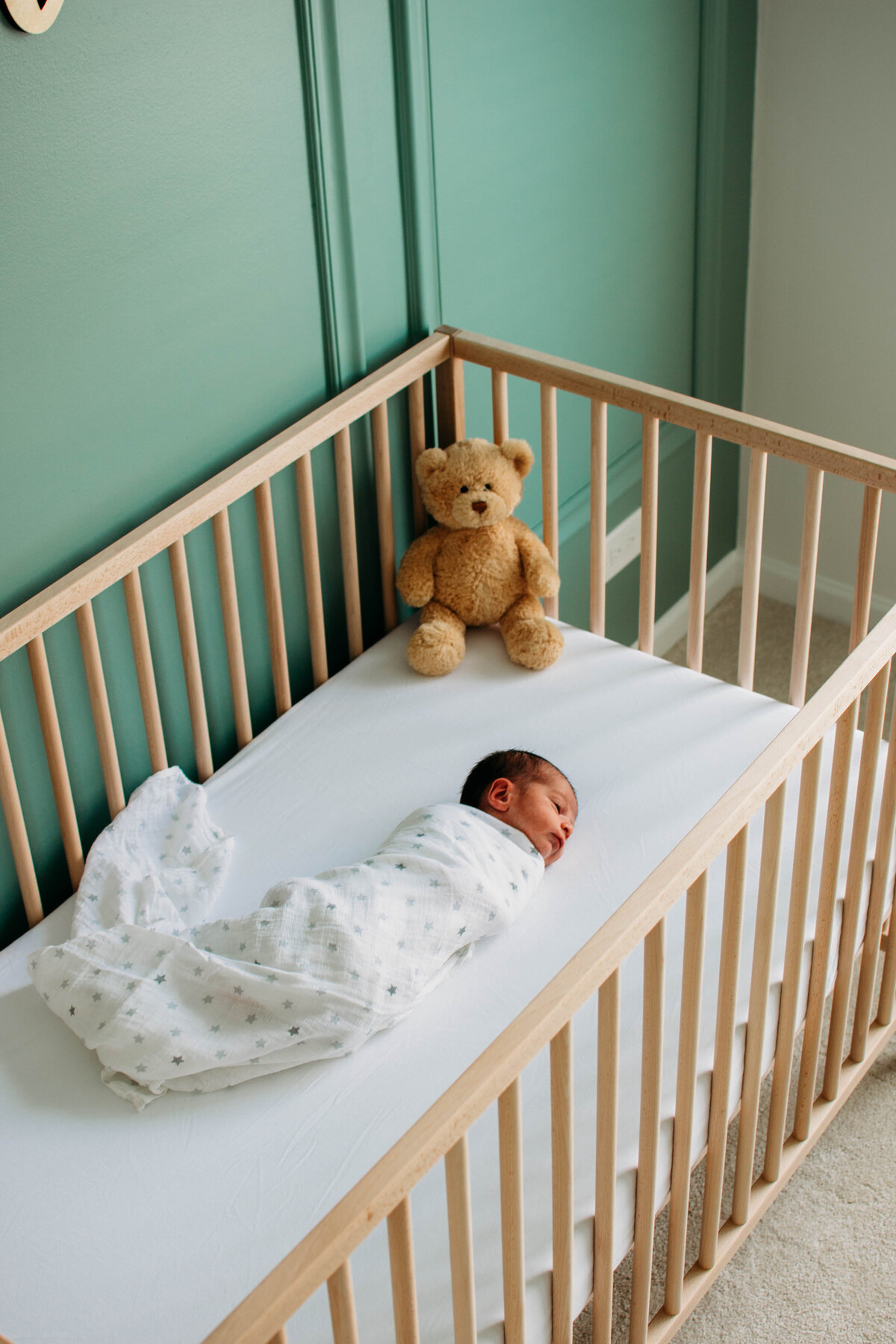 newborn baby and his lovey in the crib during a newborn photoshoot in bartlett, Il