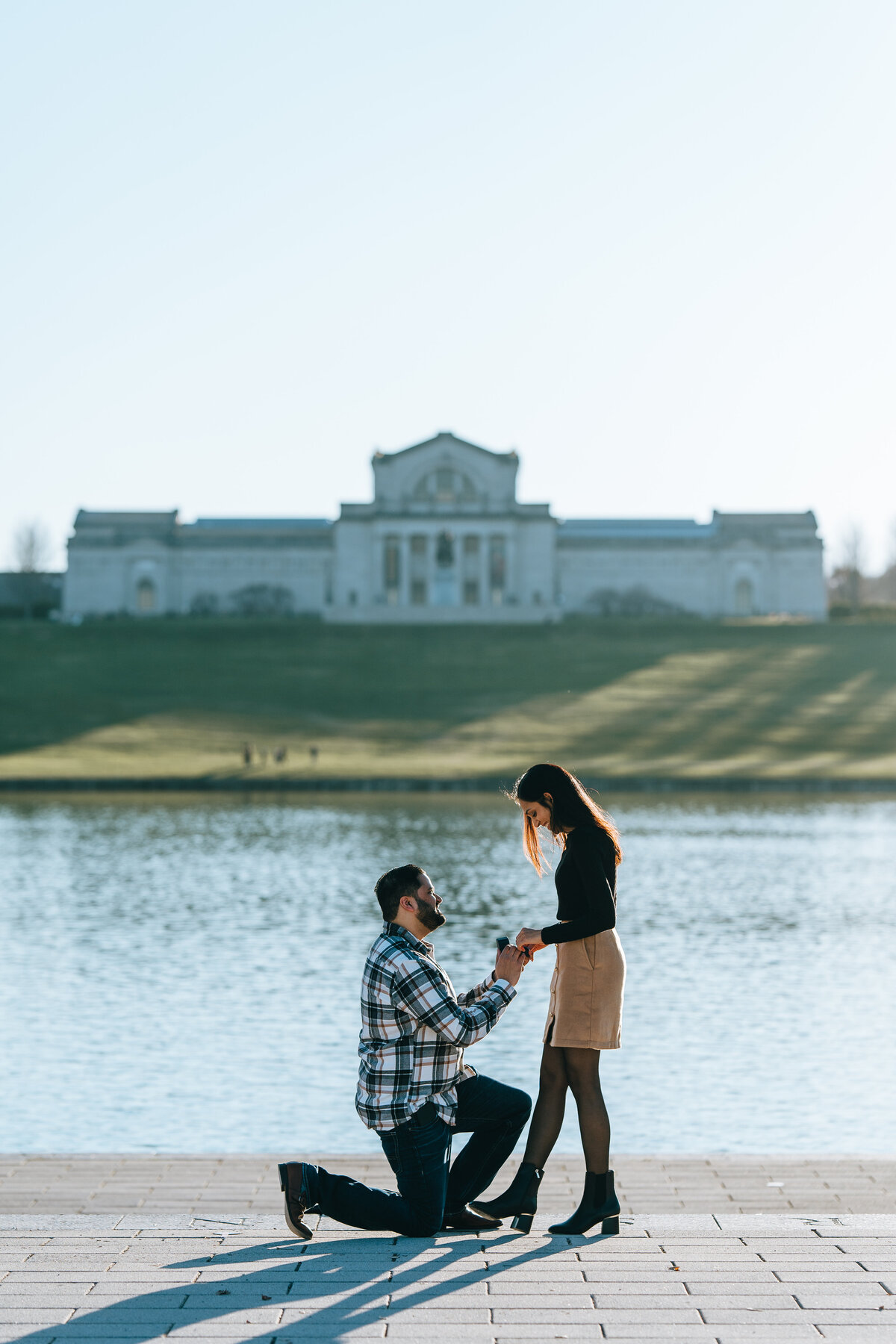 man kneeling to propose to girlfriend at forest park