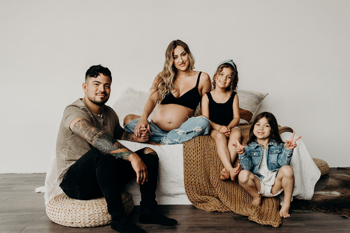 cute family of 4 studio photo on bed