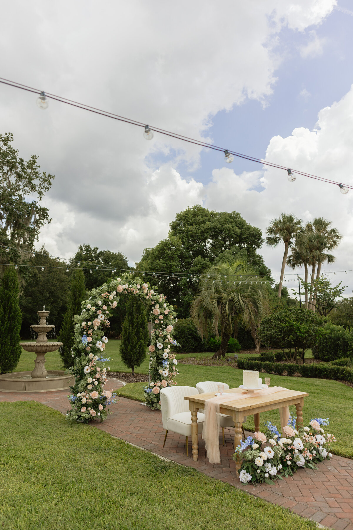Intimate Florida wedding ceremony in the backyard of The Palm Mansion with soft florals and palm tree views