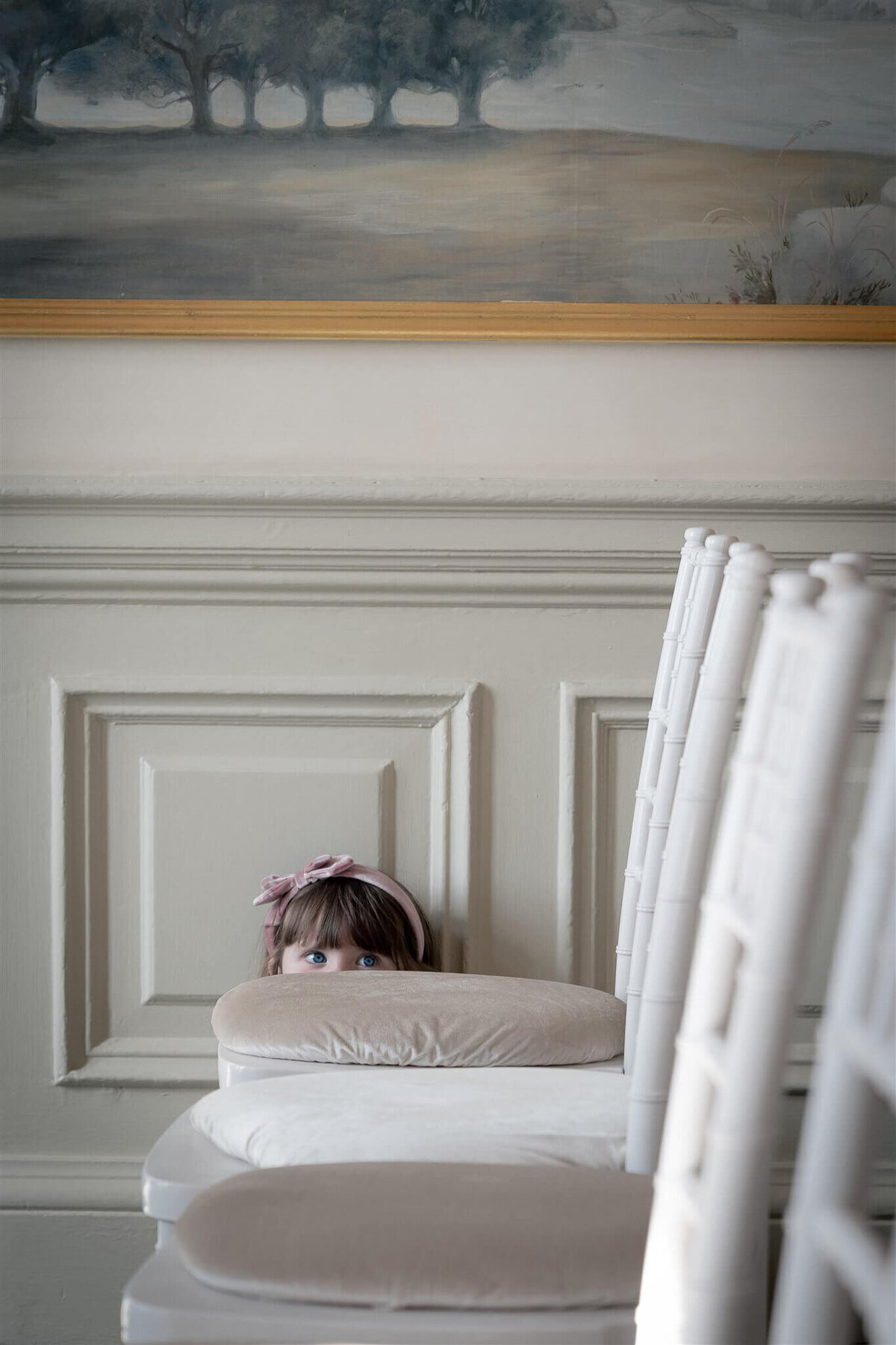 A young guest peaks over the chair as she is sat on the floor at the Balmoral in Edinburgh
