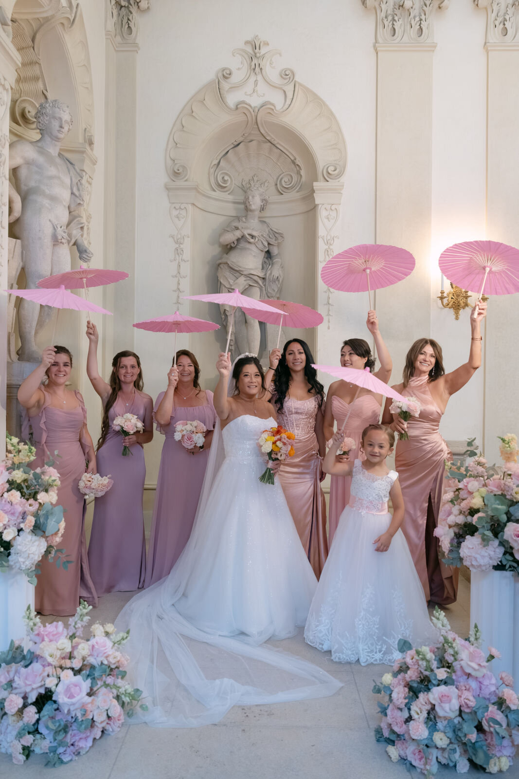 Bride and her bridal party standing in palace Daun Kinsky with pink umbrellas