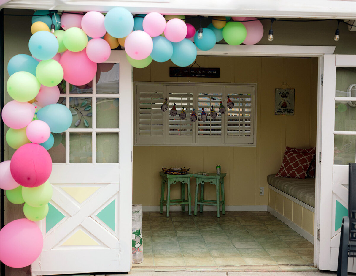 Colorful balloons decorating a poolhouse backyard for a first birthday party in Novato, captured by a San Francisco Bay Area birthday photographer.