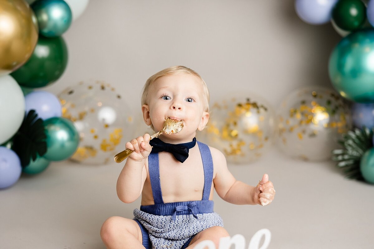 baby boy wearing bow tie and eating cake in portland studio
