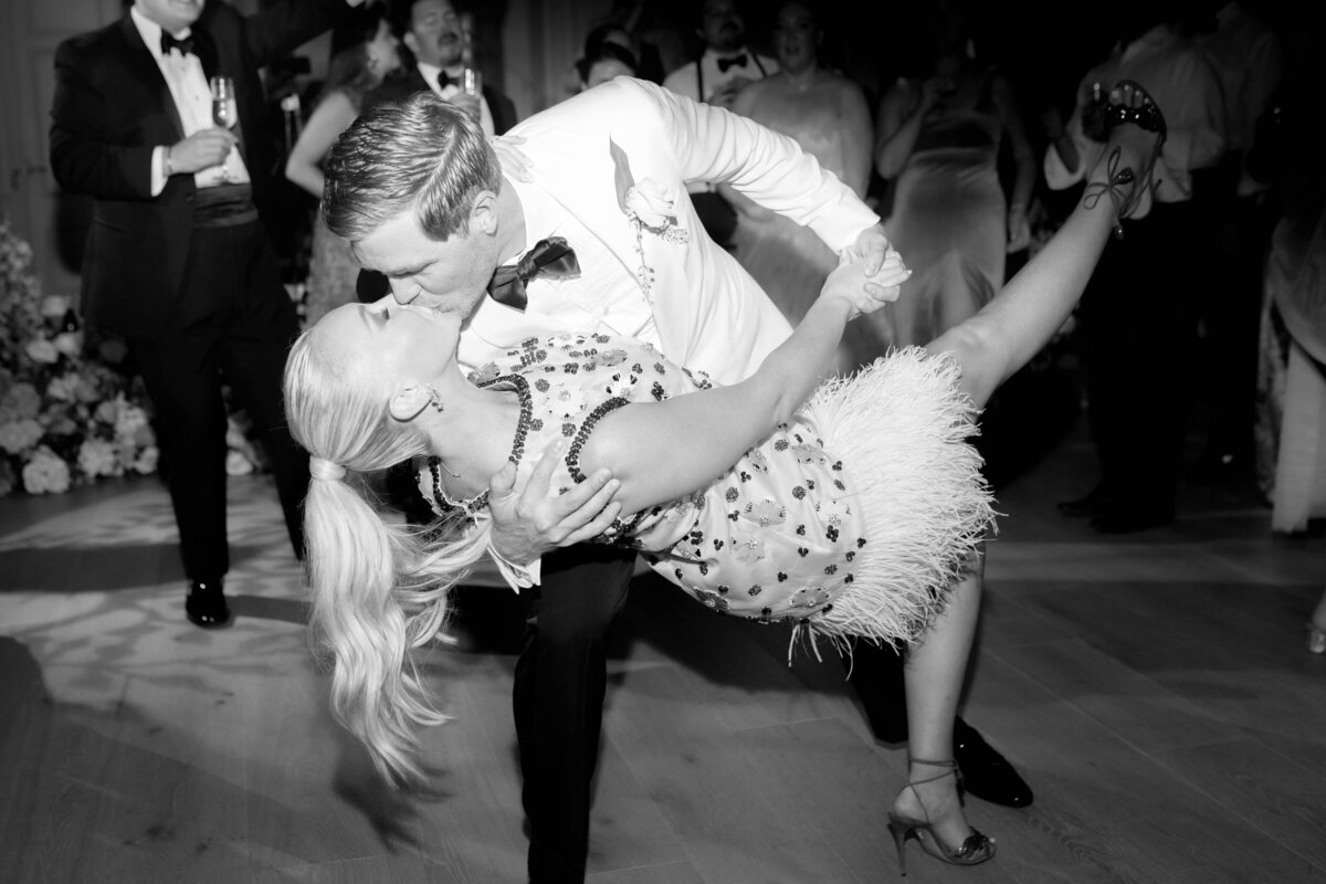 groom dips the bride and kisses her in front of their guests as they dance their first dance at their wedding party at euridge manor in the cotswolds