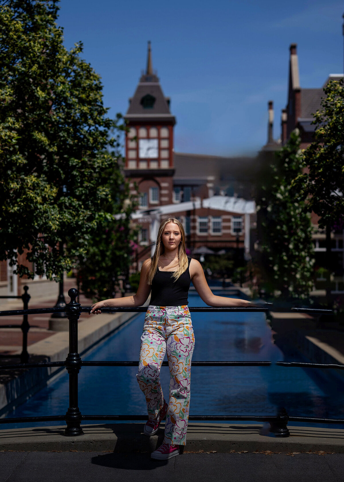 A high school senior leans on an iron railing in historic landmarks