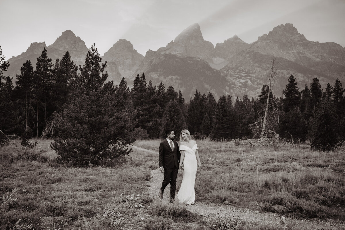 Photographers Jackson Hole capture bride and groom walking into park