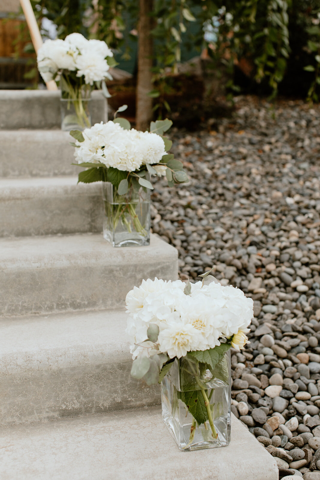 White flower arrangements along the stairs to the ceremony.