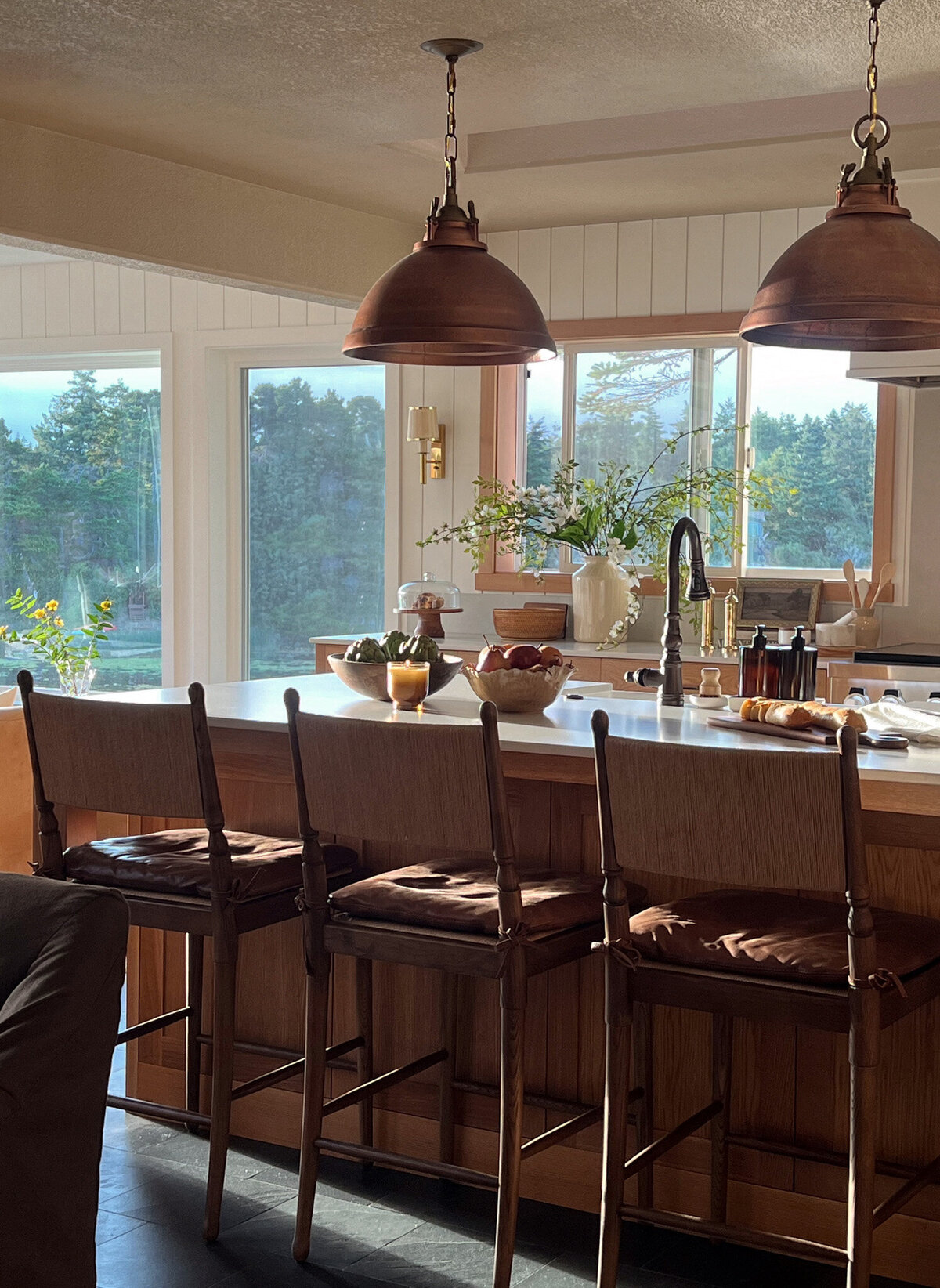 white, light kitchen, floating shelf with dishes, stove, cutting boards, bowls and dishware