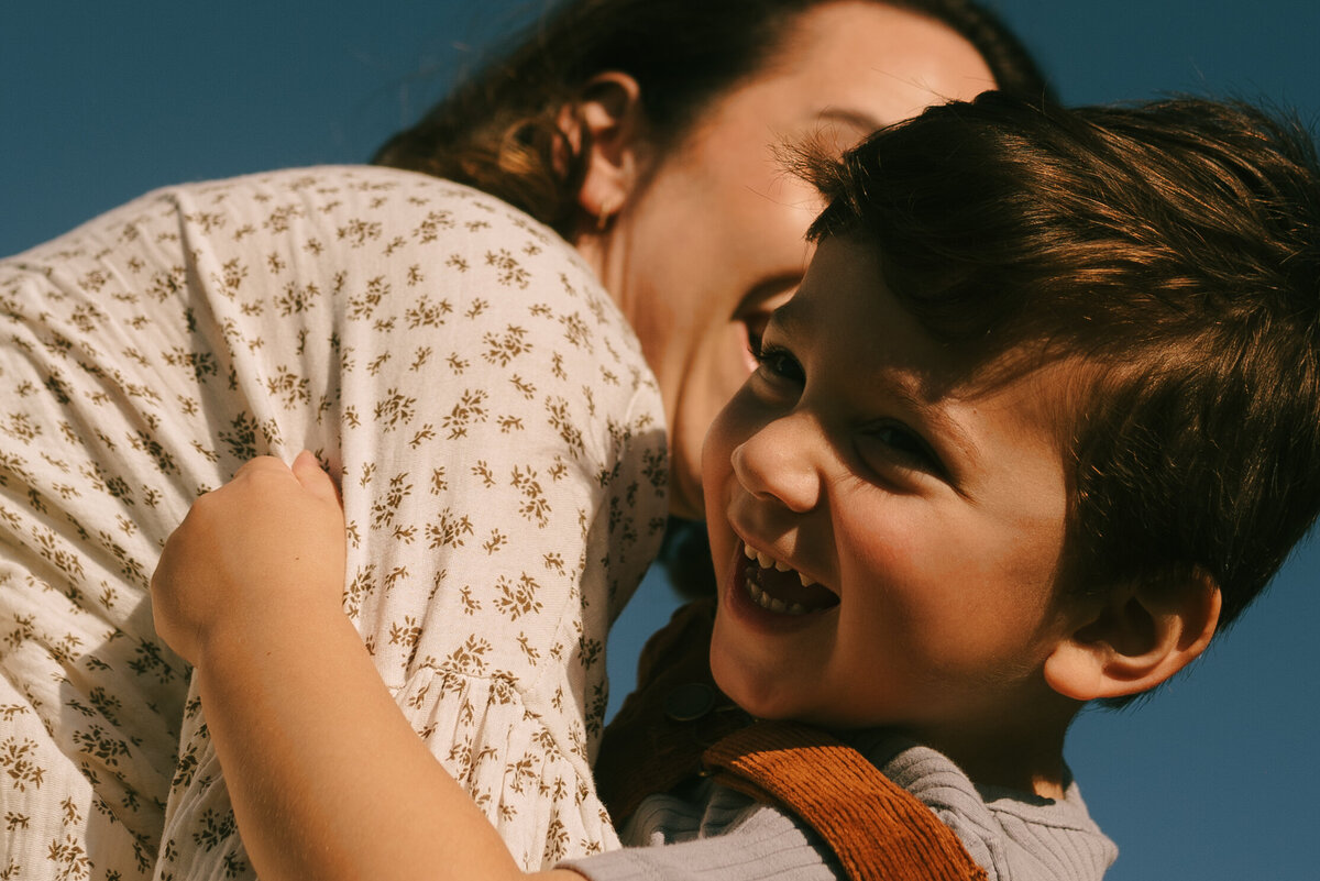 a closeup photo of a mother and her son laughing.