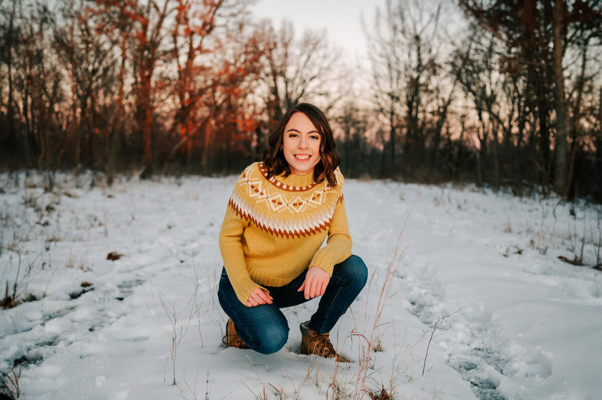 Branson Missouri senior photographer Jessica Kennedy of The Xo Photography captuers high school teen girl squating in snow in forest
